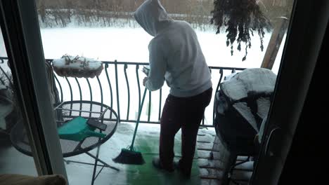 Ein-Mann-Reinigt-Seinen-Balkonboden-Von-Angesammeltem-Schnee