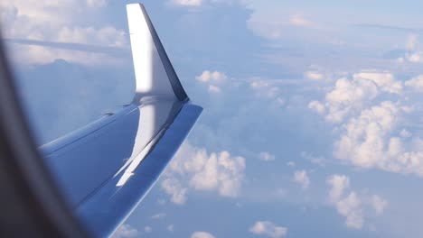 Blick-Aus-Einem-Flugzeugfenster-Auf-Wolken-Und-Den-Flügel-Des-Flugzeugs