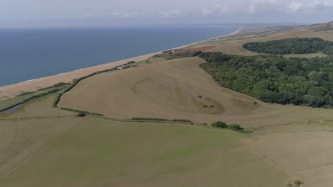 Aerial-tracking-high-above-the-rolling-fields-of-Dorset,-amazing-scenery-as-far-as-the-horizon