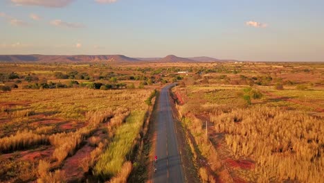Beautiful-cinematic-aerial-over-a-lone-road-passing-through-the-barren-dry-fields-of-rural-Bahia,-Brazil