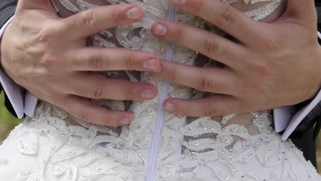 Close-up-slow-motion-view-of-a-bride's-waist-as-her-new-husband-puts-his-hands-around-her-waist