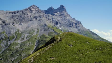 Passing-close-to-hikers-standing-on-a-hill-next-to-cross-Dents-de-Morcles-in-the-background-Croix-de-Javerne---the-Alps,-Switzerland