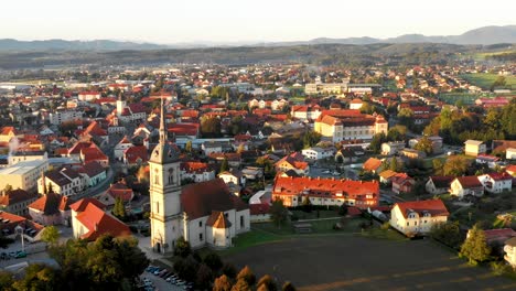 Aerial-Panorama-view-of-small-medieval-european-town-Slovenska-Bistrica,-Slovenia-with-church-and-castle-in-sunrise