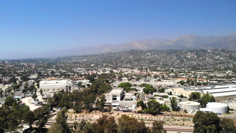 Aerial-shot-flying-over-the-city-buildings-and-luxury-homes-with-mountains-in-the-distance-in-downtown-Santa-Barbara