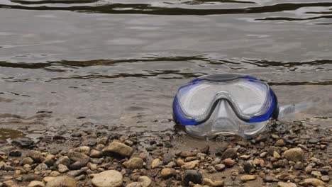 Goggles-on-a-pebble-beach-in-slow-motion