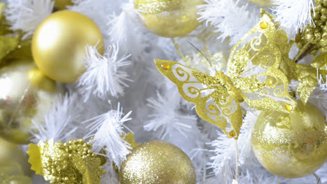 Detail-Eines-Weißen-Weihnachtsbaums,-Der-Mit-Goldenen-Schmetterlingen-Und-Objekten-Geschmückt-Ist
