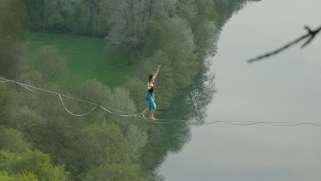 Cinematic-athlete-on-high-line-slack-line-over-river-in-high-mountains-of-Germany