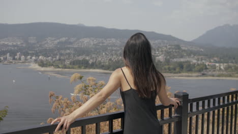 Junges-Asiatisches-Mädchen-Genießt-Die-Aussicht-Am-Aussichtspunkt,-Im-Hintergrund-Die-Nordküste-Von-Vancouver,-Zeitlupe