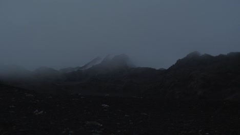 dramatic-iceland-landscape-at-night,-camera-movement,-camera-pan-from-right-to-left-to-reveal-a-person-overlooking-the-whole-scene,-wide-angle-lens