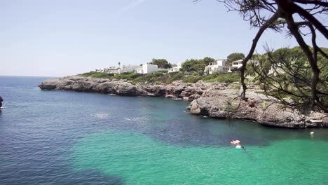 SLOW-MOTION:-Tilt-down-to-crystal-clear-sea-of-Mallorca-island,-Spain
