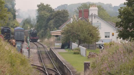 Vintage-Tren-Bajando-Las-Vías-En-La-Estación-De-Tren-De-Washford-En-Somerset,-Inglaterra