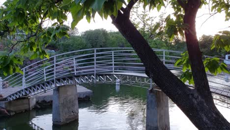 Hermoso-Puente-Peatonal-Arqueado-Blanco-Sobre-Un-Pequeño-Río-En-El-Parque-De-Medicina-Oklahoma