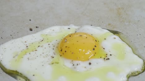 Close-up-of-a-fried-egg-on-grill-as-cooking-oil-is-added-to-the-egg