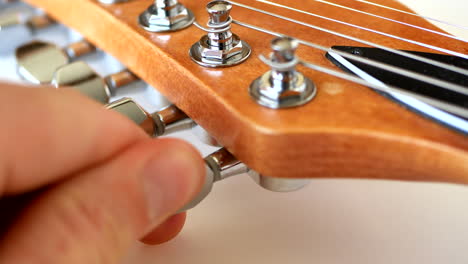 Tuning-a-wood-grain-electric-guitar-at-the-maple-headstock
