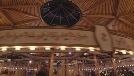 Top-part-of-fast-spinning-Carousel-with-warm-lights,-Interior
