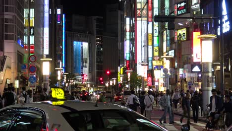 Autos-Und-Tausende-Von-Menschen-Laufen-Im-Zeitraffer-über-Das-Berühmte-Shibuya-In-Tokio,-Japan