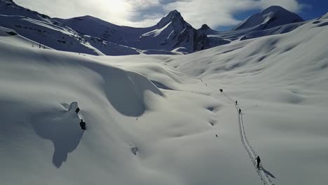 Drohne-Fliegt-An-Backcountry-Skifahrern-Vorbei,-Die-Auf-Der-Skipiste-Aufsteigen