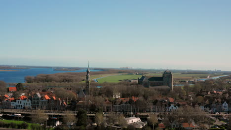 Aerial:-The-historical-town-of-Veere-with-an-old-harbour-and-churches,-on-a-spring-day