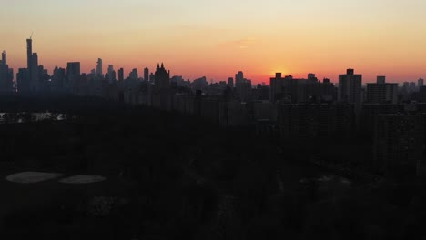 Epic-drone-slide-over-the-top-of-New-York-City's-Central-Park-at-gorgeous-sunset-golden-hour