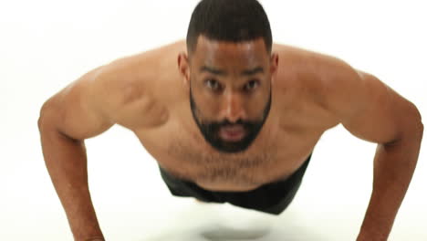 Strong-fit-athletic-African-American-man-doing-pushups-in-front-of-a-white-background