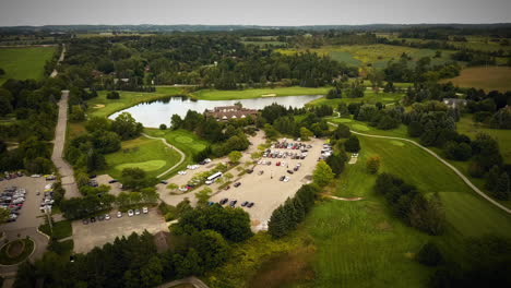 Drohne-Fliegt-über-Einen-Wunderschönen-Golfplatz,-Umgeben-Von-Weiten-Feldern