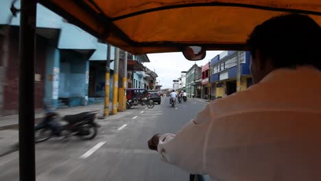 Riding-on-a-motor-bike-carriage-through-the-streets-of-Iquitos,-Peru