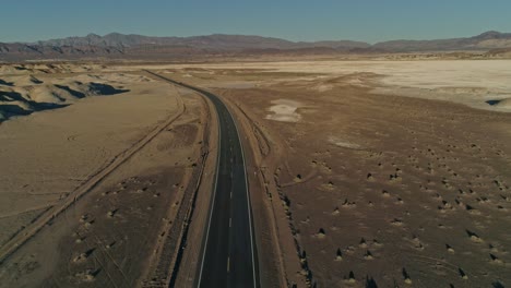 High-aerial-view-pulling-away-from-an-empty-highway-in-the-desert
