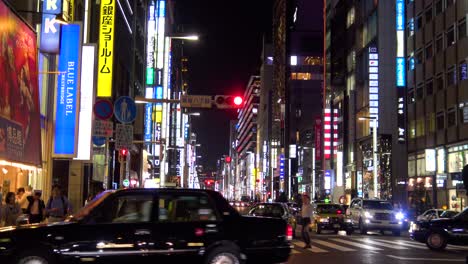 Der-Blick-Auf-Die-Berühmte-Einkaufsstraße-Ginza,-Autos-Und-Gehende-Menschen-In-Der-Nacht