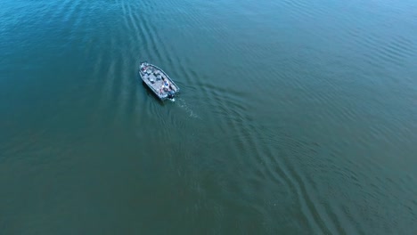 Drone-footage-of-a-camouflage-bass-boat-idling-around-a-small-lake-in-southern-Illinois