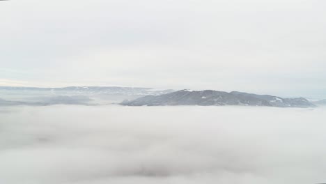 Toma-Panorámica-De-Un-Paisaje-Invernal-Por-Encima-De-La-Línea-De-Niebla