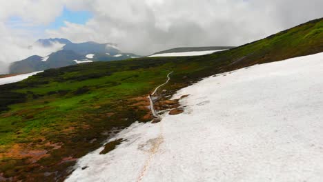 Daisetsuzan-National-Park-drone-flight,-hiking-on-the-trail-through-the-ice-and-snow