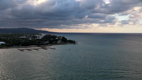 Time-lapse-view-departing-Kingston,-Jamaica-by-boat-under-a-cloudy-sky-at-sunset