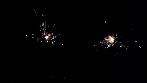 Two-random-moving-sparking-sparklers-in-a-dark-room