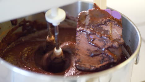 A-chef-using-an-electric-mixer-and-a-spatula-to-make-delicious-vegan-chocolate-cake-batter-while-baking-dessert-in-a-kitchen