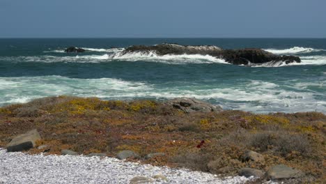A-small-offshore-island-being-pounded-by-waves-on-the-Atlantic-coast-with-a-rocky-foreground