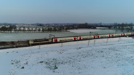 Luftaufnahme:-Ein-Zug-Fährt-An-Einem-Wintertag-Durch-Eine-Verschneite-Landschaft