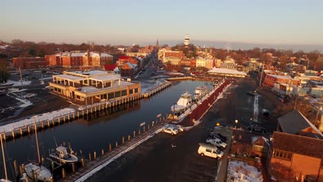 Flying-through-seagulls-moving-towards-downtown-Annapolis-Main-Street-and-Maryland-state-capital-building-during-winter-sunrise