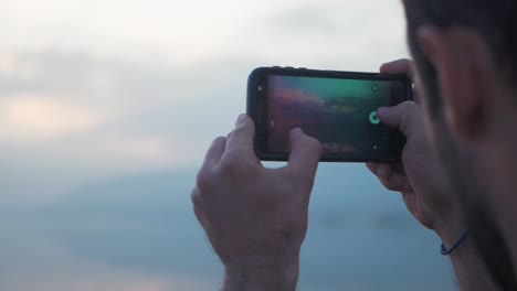 Man-videos-golden-hour-sunset-on-his-phone-LONG-CLIP-slow-motion