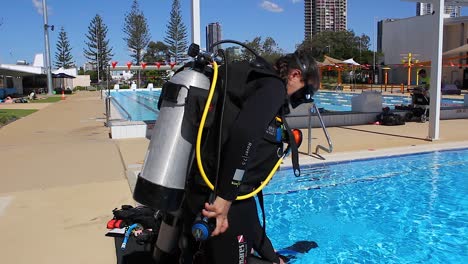 A-female-scuba-diver-getting-ready-to-commence-a-practice-dive-in-a-pool