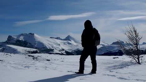 Hombre-Caminando-En-La-Nieve-En-La-Cima-De-La-Montaña