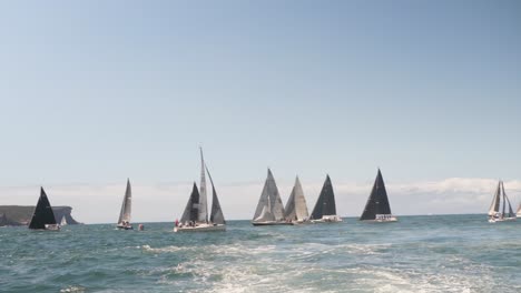 View-from-the-back-of-a-boat-of-many-sail-boats-on-the-ocean-practicing-a-race