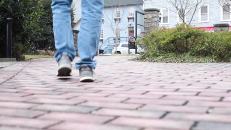 Man-Walking-slowly-on-a-stone-paved-walkway