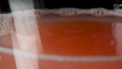 Macro-shot-of-a-drop-from-a-grapefruit-juice-in-slow-motion