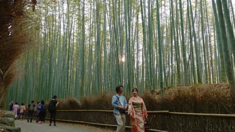 Hombre-Y-Mujer-Vestidos-Con-Kimono-Japonés-Caminando-En-El-Bosque-De-Bambú-De-Arashiyama-Junto-Con-Otros-Turistas-Y-Visitantes