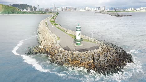 Aerial-cinematic-view-circling-around-the-lighthouse-of-Farol-Do-Molhe-Da-Barra-De-Itajaí,-Santa-Catarina,-Brazil