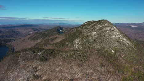 Aerial-slide-to-the-right-past-a-far-off-snow-dusted-mountain-in-Maine