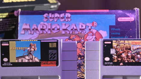 Vintage-Super-Nintendo-Cartridges-with-Box-in-Background-in-Purple-Light-SLIDE-LEFT