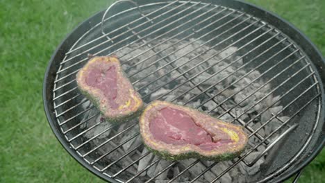 Steak-covered-with-minced-meat-and-cheddar-cheese-is-being-cooked-on-a-grill