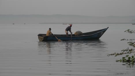 Zwei-Afrikanische-Männer-Paddeln-Mit-Ihrem-Traditionellen-Hölzernen-Angelkanu-Auf-Ruhigem-Wasser-Im-Lake-Victoria