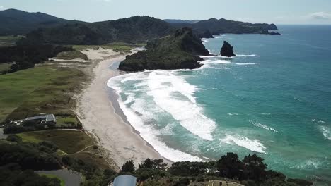 aerial-shot,-rising-up-focus-on-the-beach,-Awana-Bay,-Great-Barrier-Island,-New-Zealand